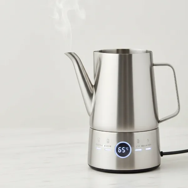 Close-up of an automatic milk frother with multiple settings and a precise pouring spout